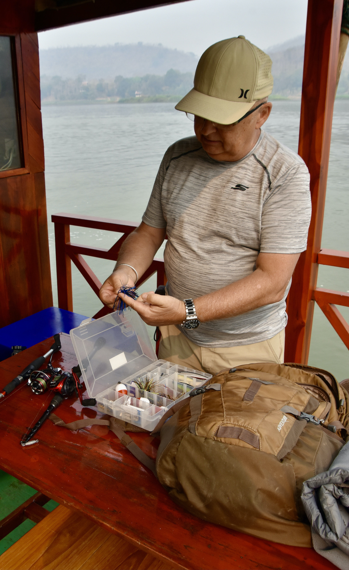 Claude Inspects His Fishing Tackle on the Mekong River